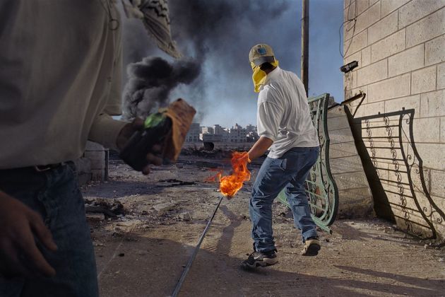 In una delle prime manifestazioni della seconda Intifada palestinese, i dimostranti lanciano pietre e molotov contro i soldati, che sparano munizioni vere e proiettili di gomma, a volte letali. Cisgiordania, Ramallah, 2000 Â© James Nachtwey/Contrasto