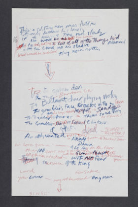 A set of working lyrics in Joe Strummer and Mick Jones' handwriting for the song The Card Cheat, 1979. The Card Cheat was released on the London Calling album in 1979. It features approximately 24 lines in blue pencil and red ink on white notepaper, with extensive additions and deletions as Strummer and Jones worked out the song's wording. © The Clash