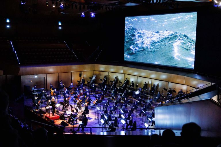 Roma, Auditorium Parco della Musica 11 11 2021 Orchestra e Coro dell’Accademia Nazionale di Santa Cecilia Philip Glass Ensemble direttore Michael Riesman Philip Glass Koyaanisqatsi La vita senza equilibrio regia Godfrey Reggio fotografia Ron Fricke montaggio Alton Walpole/Ron Fricke proiezione del film (1982) con musiche dal vivo Philip Glass Ensemble direttore musicale, tastiere, Michael Riesman voce e tastiere, Lisa Bielawa sound, Dan Bora sassofono, Peter Hess onstage sound, Ryan Kelly tastiere, Mick Rossi sassofono e flauto, Sam Sadigursky flauto e piccolo, Andrew Sterman ©Accademia Nazionale di Santa Cecilia / Musacchio, Ianniello & Pasqualini