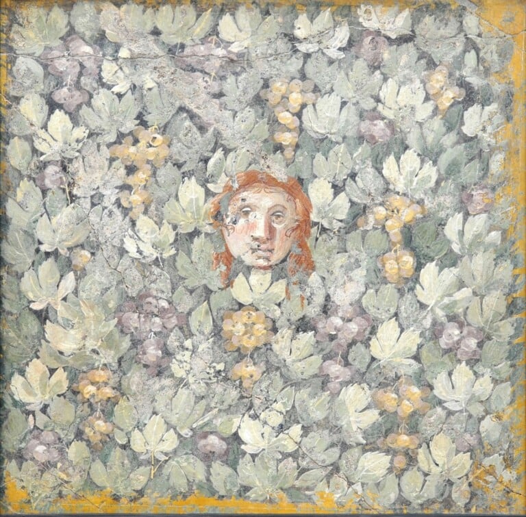 Maschera su foglie e grappoli di vite, Pompei, Casa delle Colombe a Mosaico, triclinio 13, parete est, sezione centrale, 20 10 a.C. – III stile, affresco, 55 x 55 cm, MANN, inv. 9798