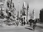 Robert Capa, Gente lungo una strada fiancheggiata da edifici distrutti, Berlino, Germania, agosto 1945 © Robert Capa © International Center of Photography Magnum Photos