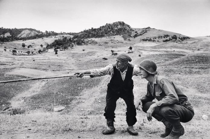 Sicilian peasant telling an American officer which way the Germans had gone, near Troina, Italy, August 1943 © Robert Capa © International Center of PhotographyMagnum Photos