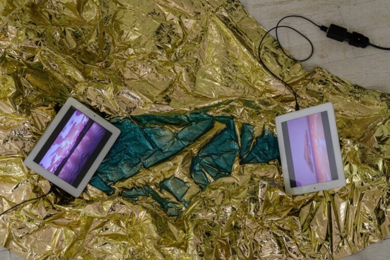 Golden hour (dettaglio), 2024, installazione (scultura con coperta isotermica di emergenza e resina epossidica, tablet con video a doppio canale), 190×120 cm; installation view da Sunset Boulevard, Curva Pura, foto di Giorgio Benni