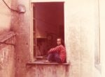 Fotografia dell’artista vestito da clown alla finestra del suo studio, Genova, 1968. Courtesy Archivio Emilio Prini