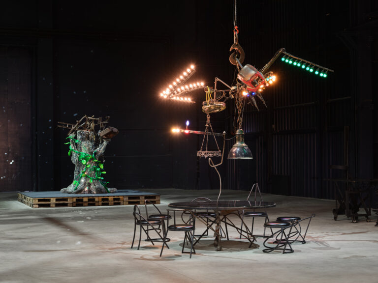 Jean Tinguely, veduta della mostra, Pirelli HangarBicocca, Milano, 2024. Primo piano: Jean Tinguely, C_a_f_é _K_y_o_t_o_, 1987, Museum Tinguely, Basel. Donation Niki de Saint Phalle. A cultural commitment of Roche. Secondo piano: Jean Tinguely e Niki de Saint Phalle, L_e_ _C_h_a_m_p_i_g_n_o_n_ _m_a_g_i_q_u_e_, 1989, Niki Charitable Art Foundation, Santee. Courtesy Pirelli HangarBicocca, Milano. Jean Tinguely: © SIAE, 2024. Foto Agostino Osio